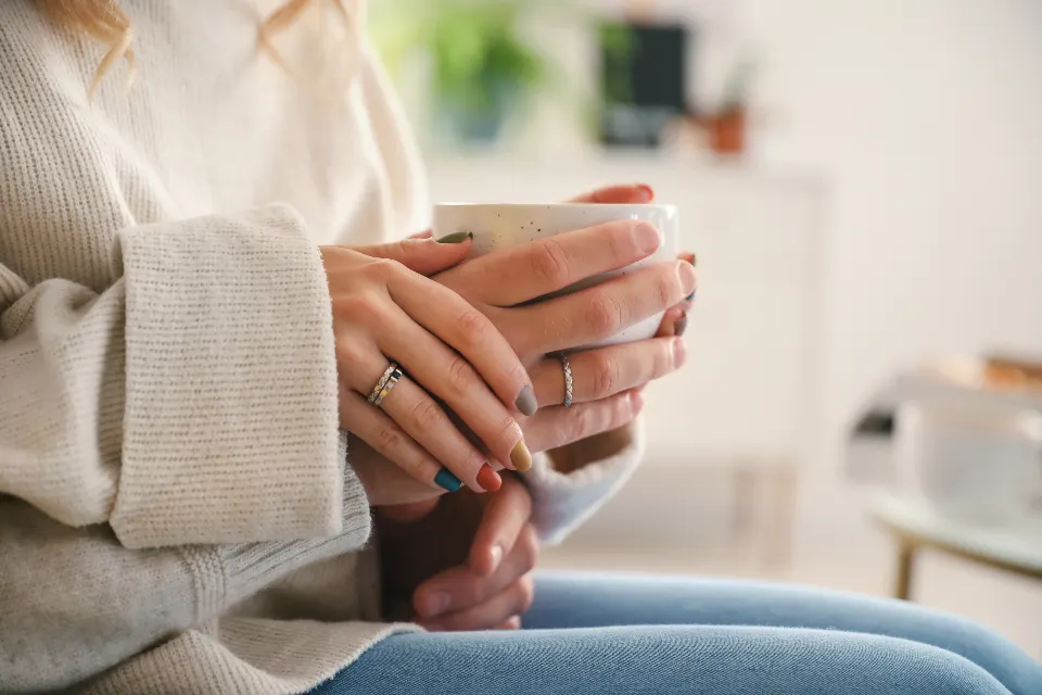 Two people talking over cups of coffee